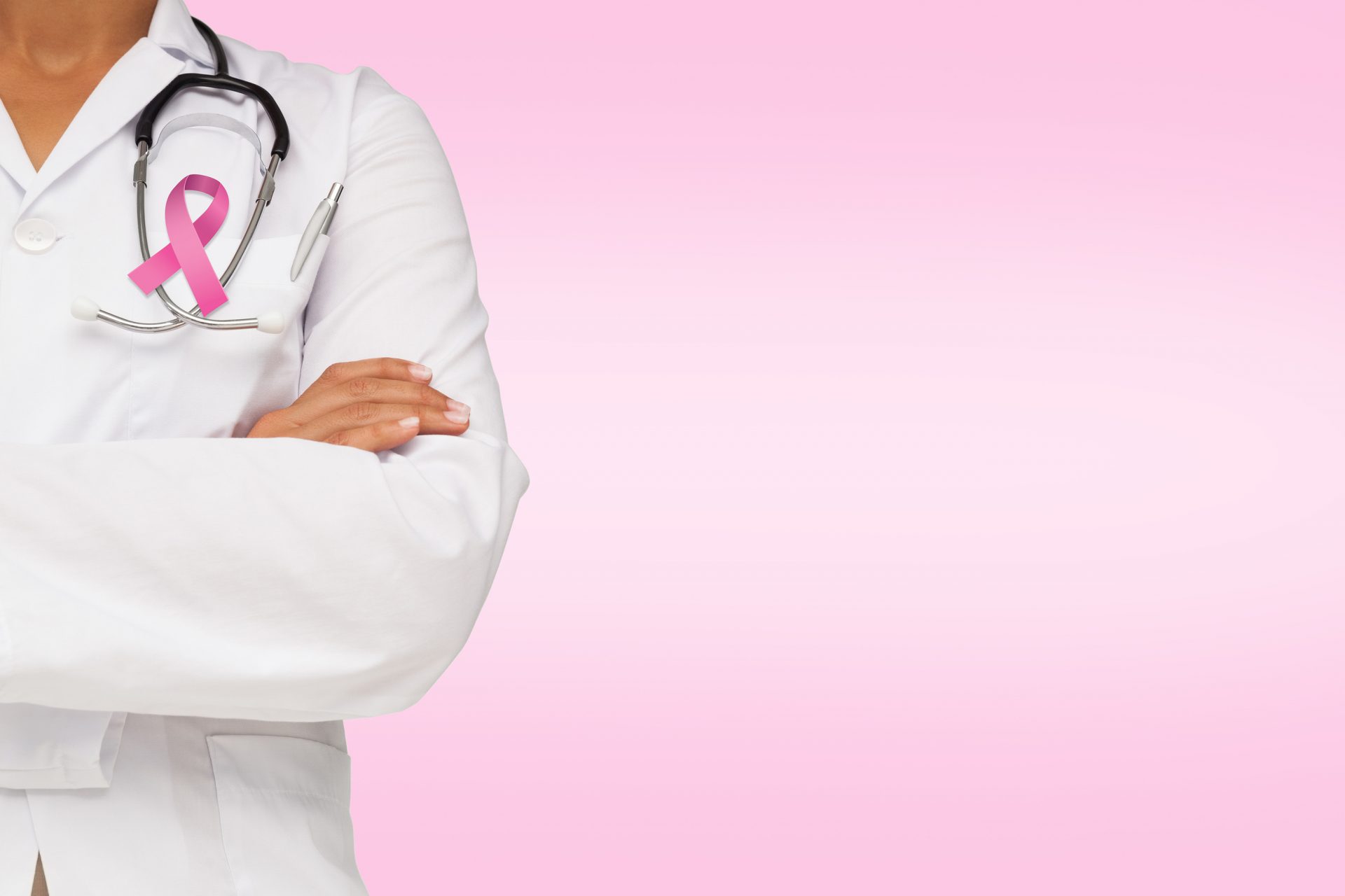 Mid section of a female doctor with skeleton model against pink